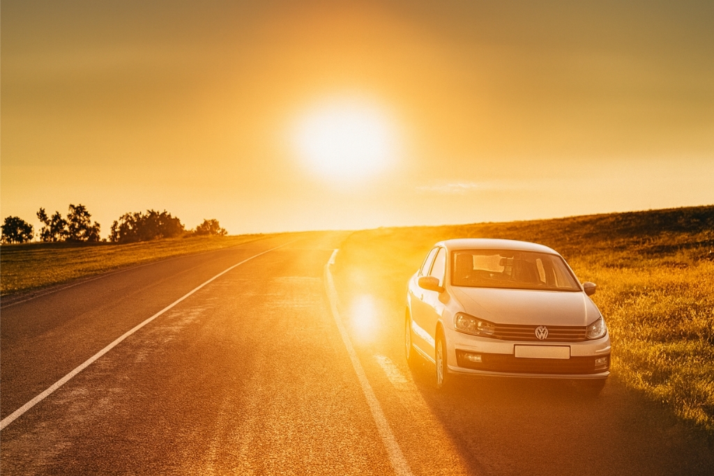 A white car parked along a rural Pennsylvania road at sunset, bathed in golden sunlight that highlights the paint’s reflective surface. This image visually supports the keyword topic: Why Ceramic Coating is Ideal for Pennsylvania Drivers by showcasing a vehicle exposed to intense sun and open-road conditions.