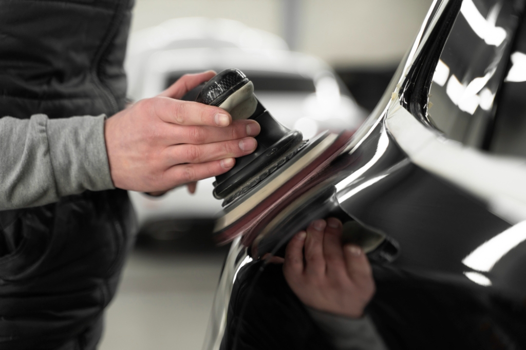 Mechanical Abrasion (Polishing or Cutting) — close-up of a technician using a dual-action polisher on a black car surface in Southampton, PA to remove stubborn ceramic coating
