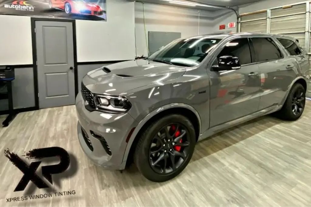 Gray SUV with premium window tint installed inside XP Automotive Restyling shop in Southampton, PA.