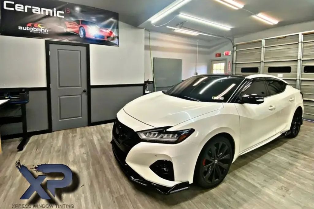 White sedan with ceramic coating and window tint inside XP Automotive Restyling shop in Southampton, PA.